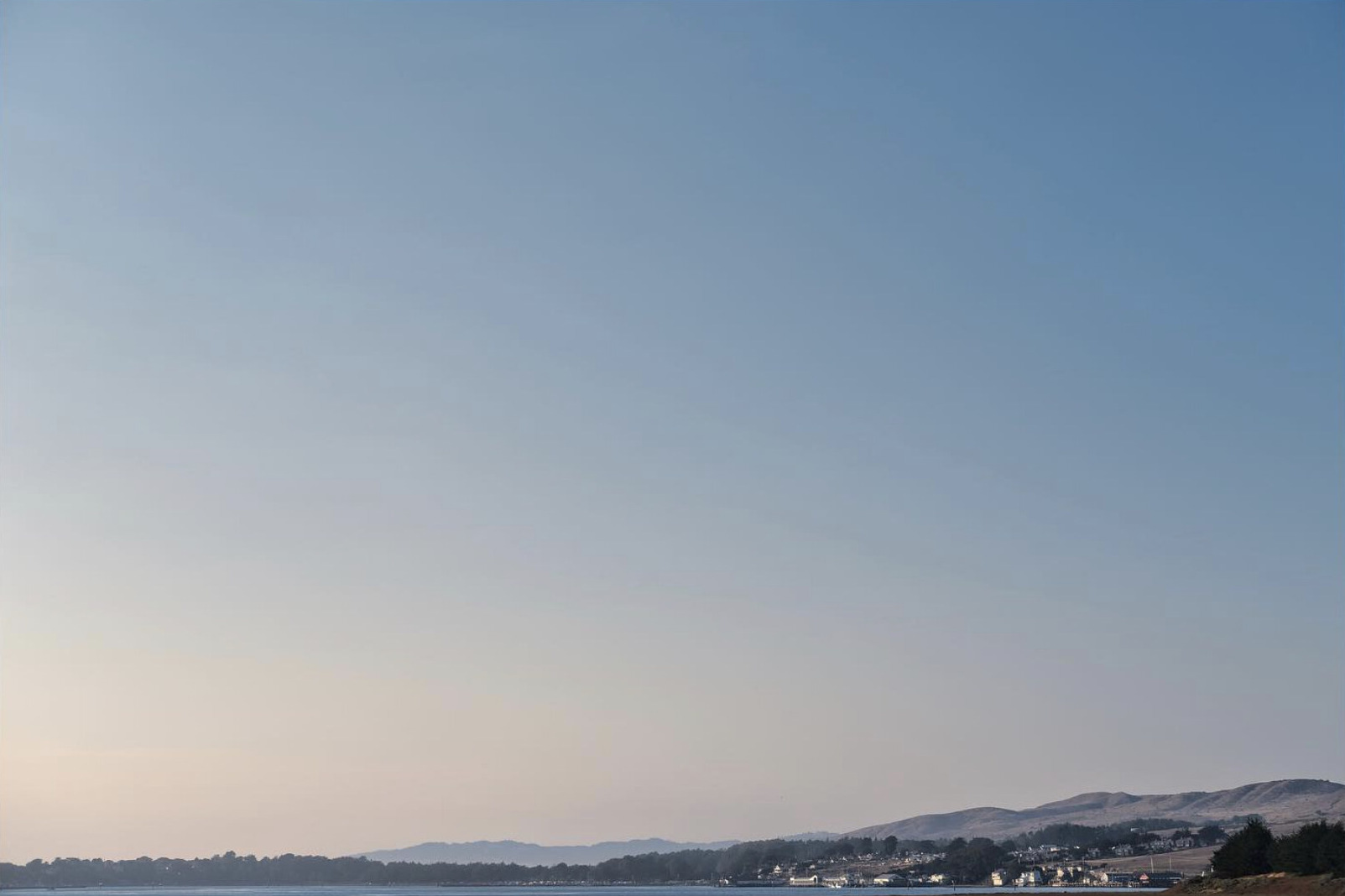 Houses along the far shore of a bay at sunset