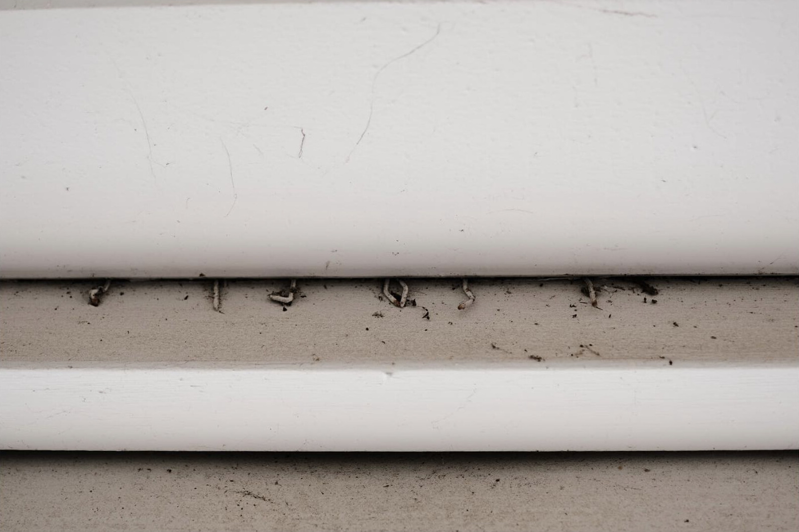 Close-up of a weathered white wall and narrow ledge